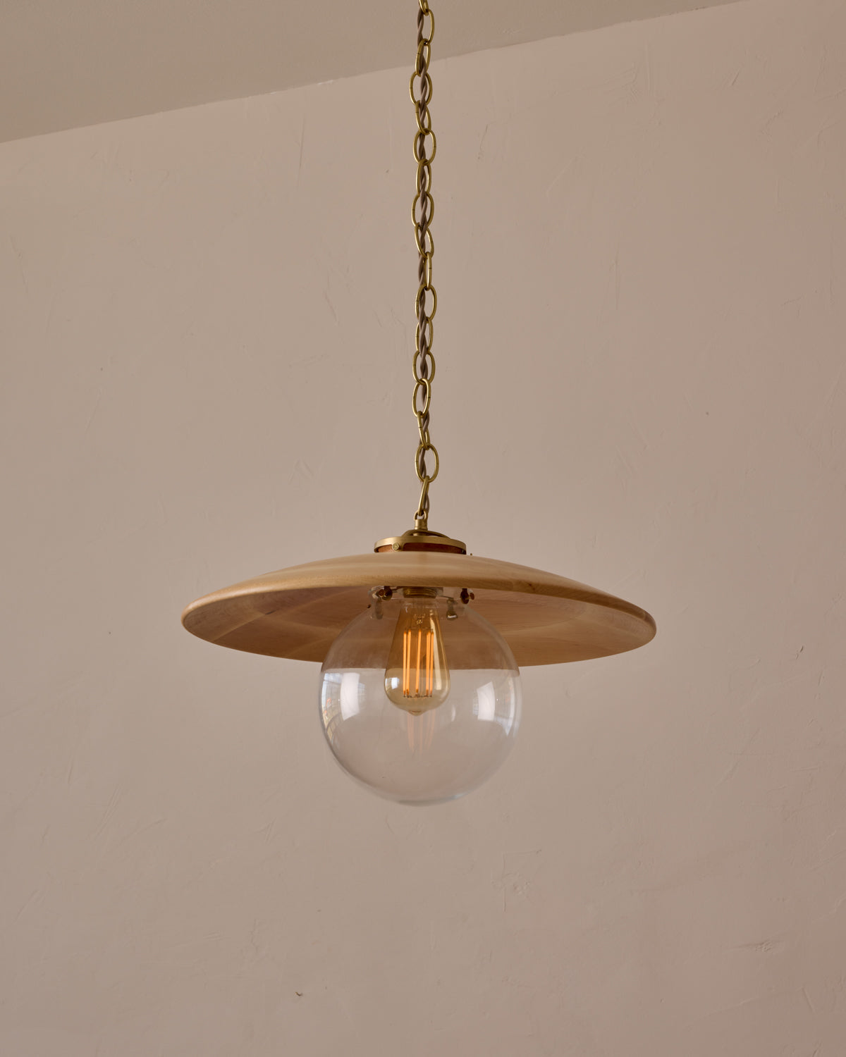 Large pendant light with oversized clear glass globe and decorative wooden clear maple shade with brass chain #shade-finish_natural maple #globe_clear glass #cord-color_beige