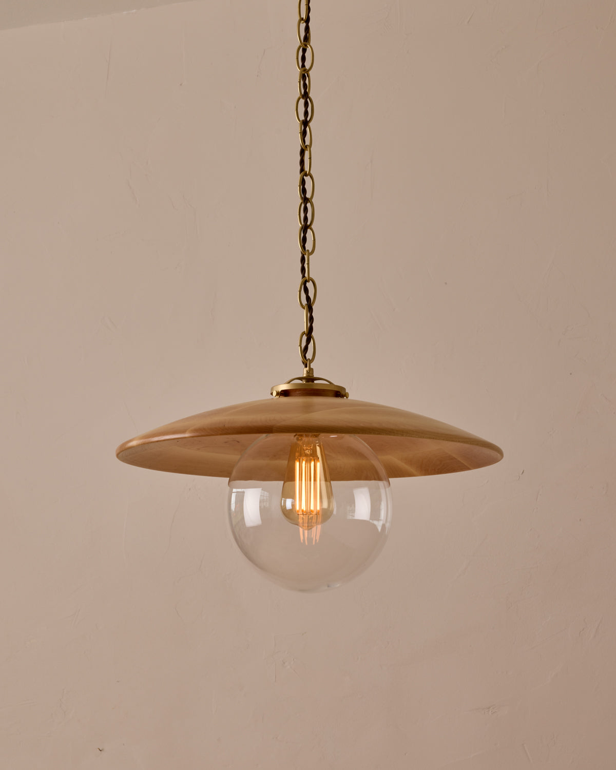 Large pendant light with oversized clear glass globe and decorative wooden clear maple shade with brass chain #shade-finish_natural maple #globe_clear glass #cord-color_brown