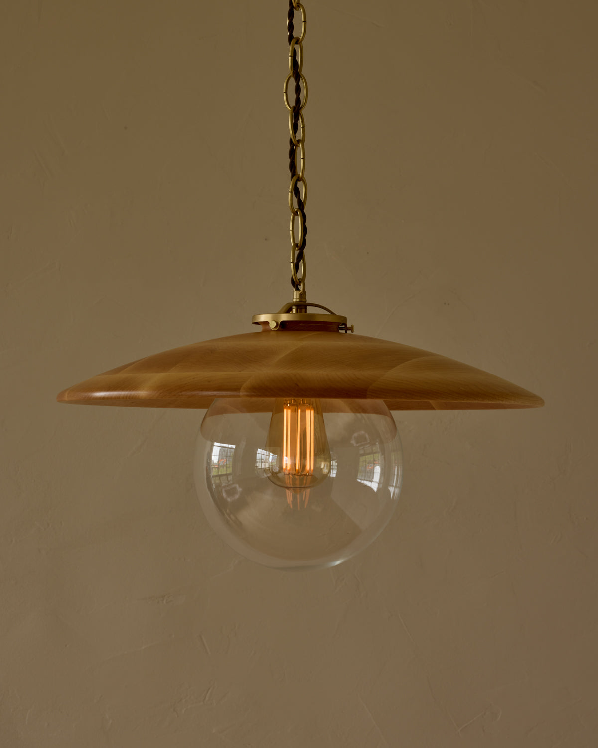 Large pendant light with oversized clear glass globe and decorative wooden clear maple shade with brass chain #shade-finish_natural maple #globe_clear glass #cord-color_brown