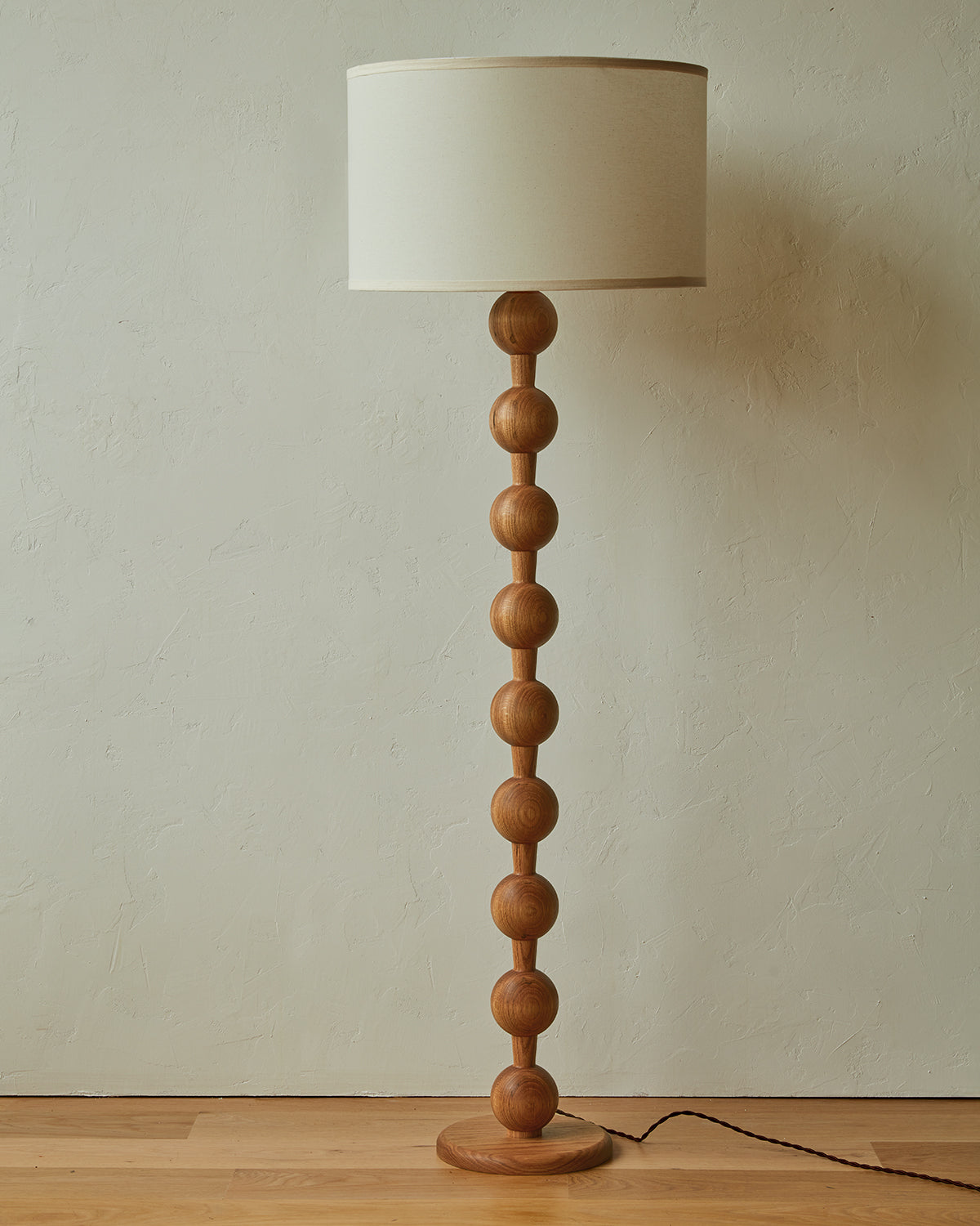 Tall sculptural solid red oak floor lamp with barbell design in natural finish with ivory linen drum shade, best seller, made in the USA
#color_natural red oak
#shade-color_ivory linen