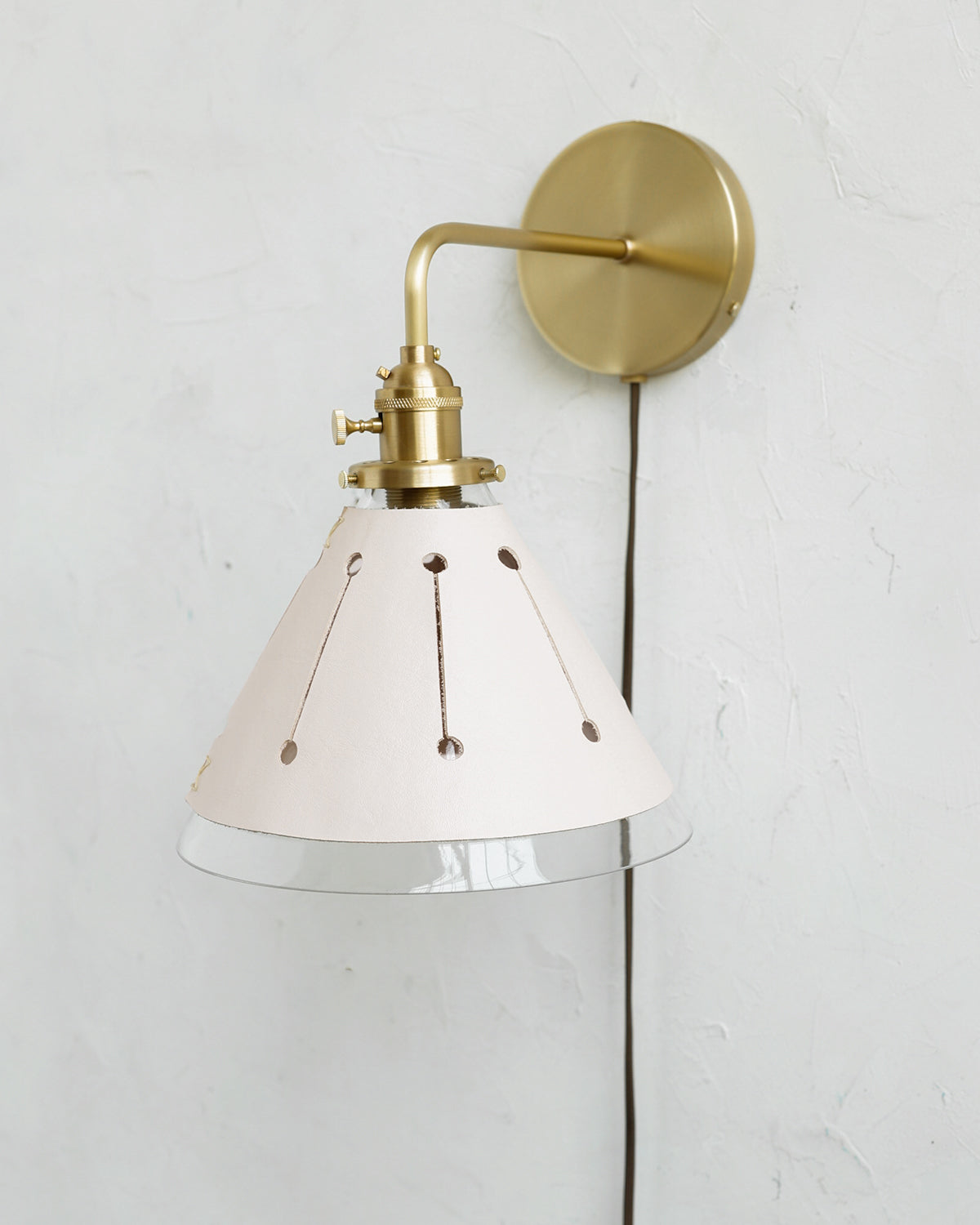 Classic satin brass plug in wall sconce with cone glass diffuser and decorative handstitched leather shade