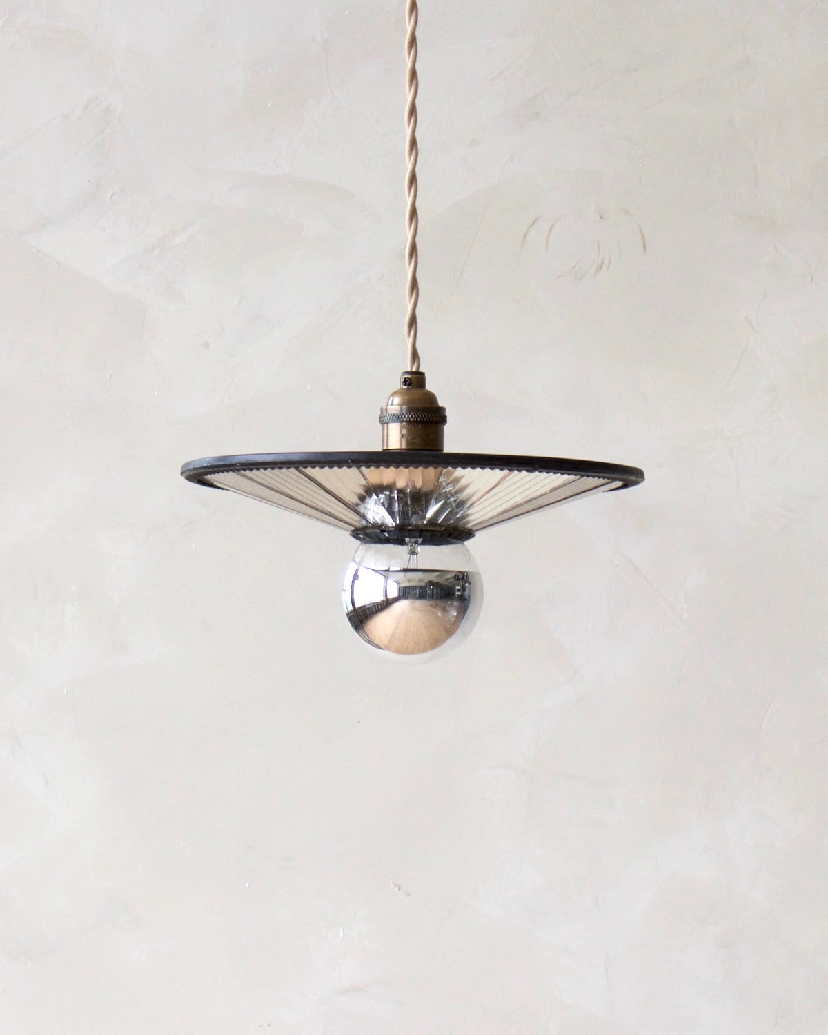 Convex modern mirrored cone pendant with oil rubbed brass. Hardwired light fixture. Simple interior design, made in the USA.