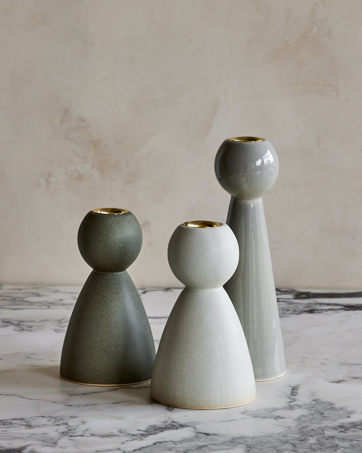 Collection of green and blue ceramic candle holders of various styles and glazes