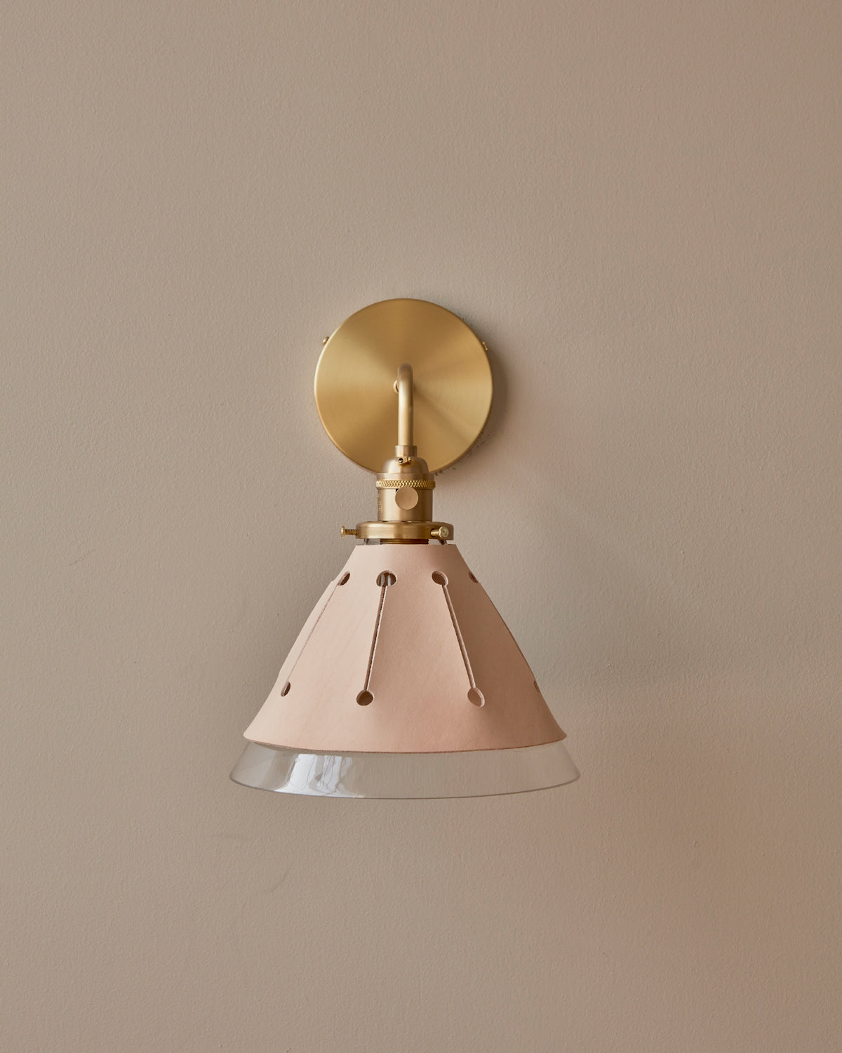 Classic hardwired satin brass wall sconce with cone glass diffuser and decorative handstitched leather shade