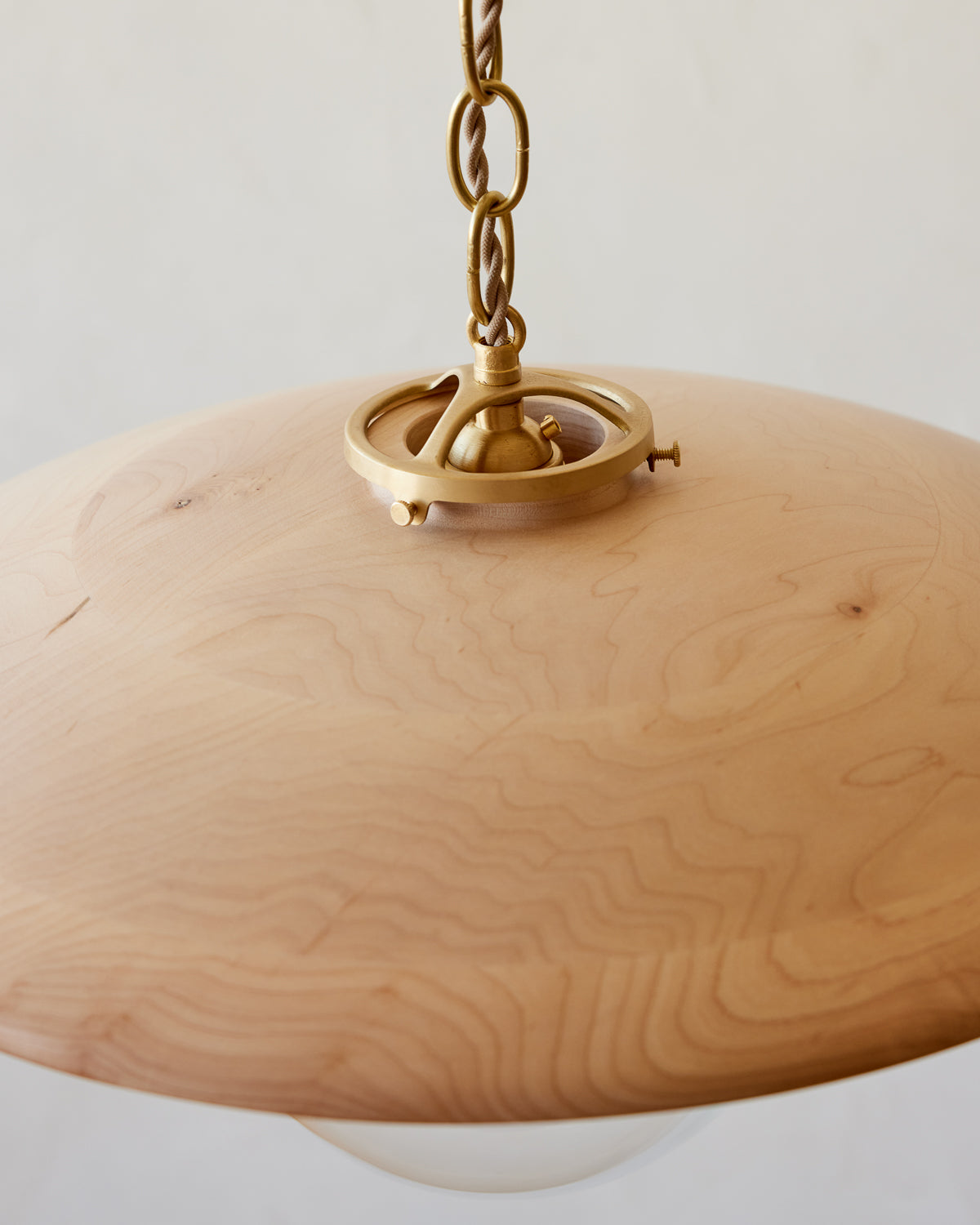 Large pendant light with oversized clear glass globe and decorative wooden clear maple shade with brass chain