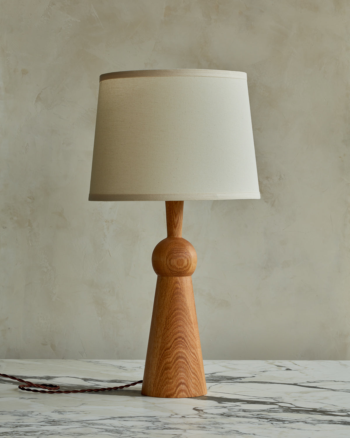 Natural red oak solid wood table lamp with gently tapered body and ivory linen shade