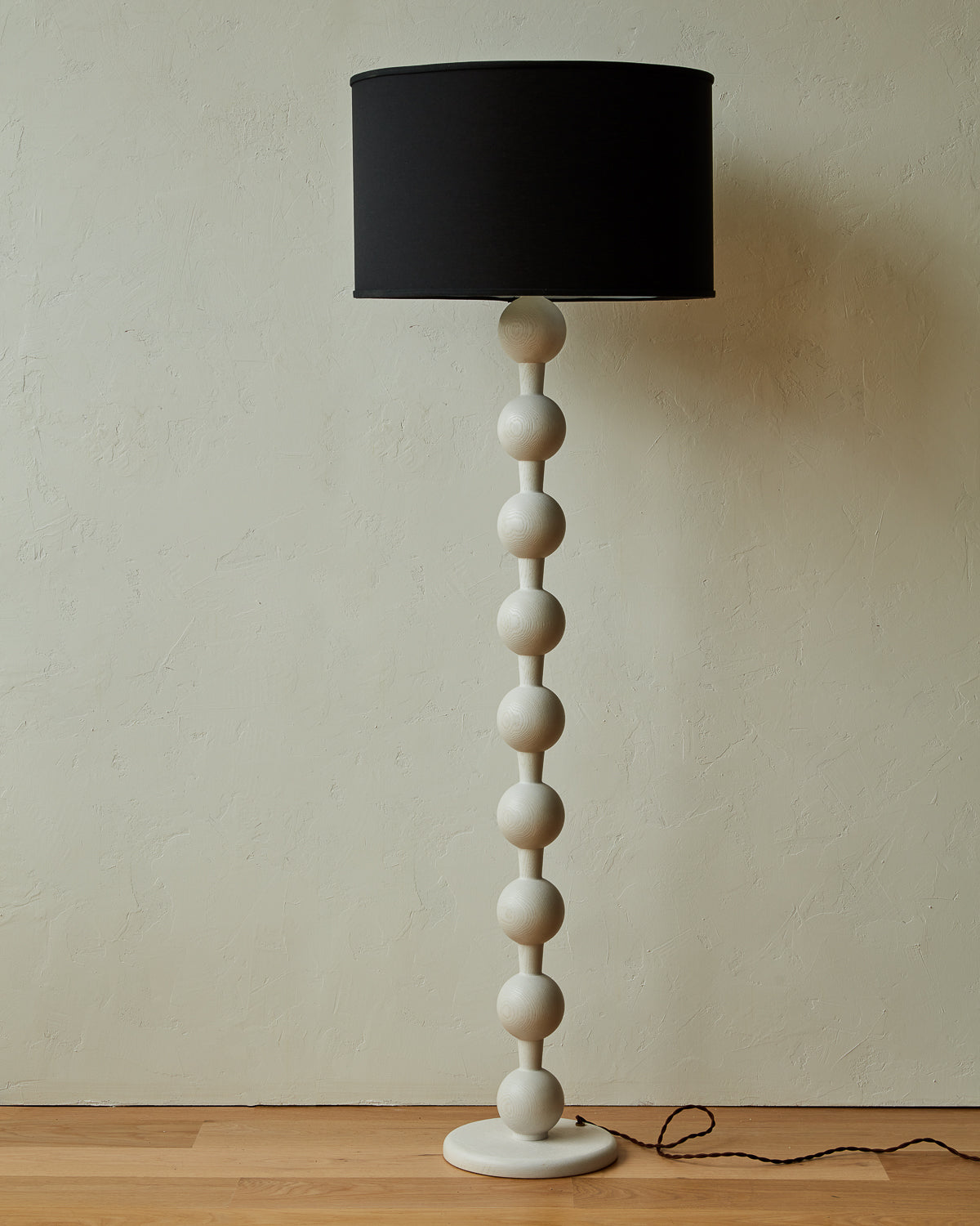 Tall sculptural solid red oak floor lamp with barbell design in white wash finish with black linen drum shade