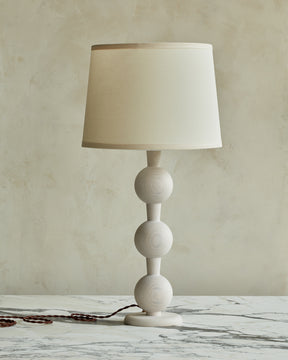 Sculptural solid wood table lamp with barbell design in white wash finish with ivory linen shade