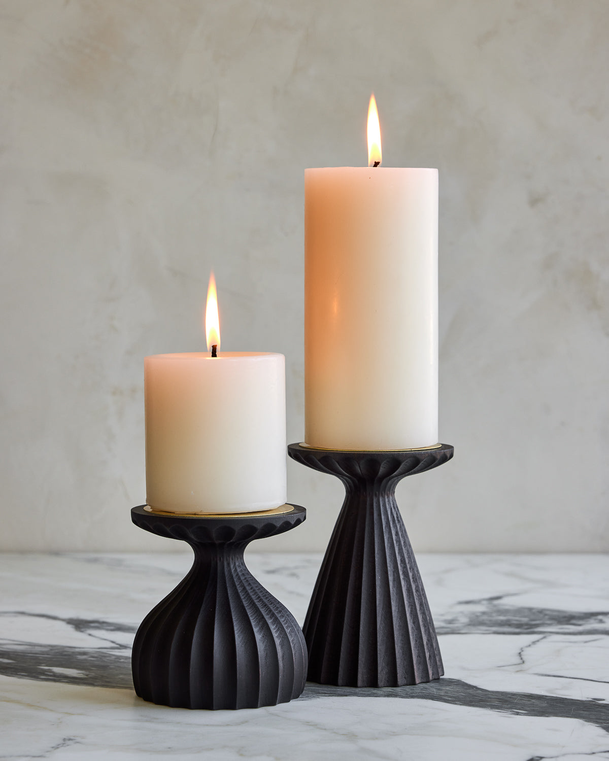 Pair of delicately grooved pillar candle holders in dark wash maple wood with shell white pillar candles