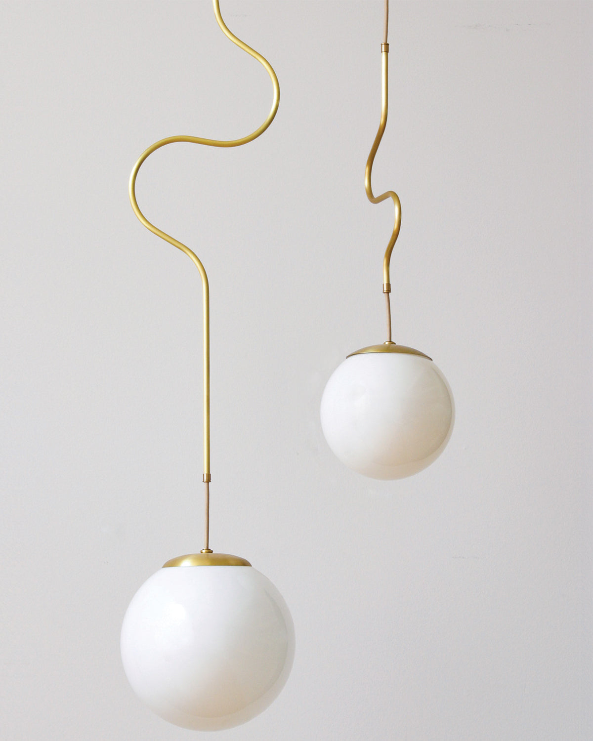 Satin brass Contour ceiling pendant lights made by Lostine in Philadelphia, Pennsylvania. Satin brass modern lighting design with white glass globe. Hardwired light fixture. Simple interior design, made in the USA. #metal-finish_satin brass