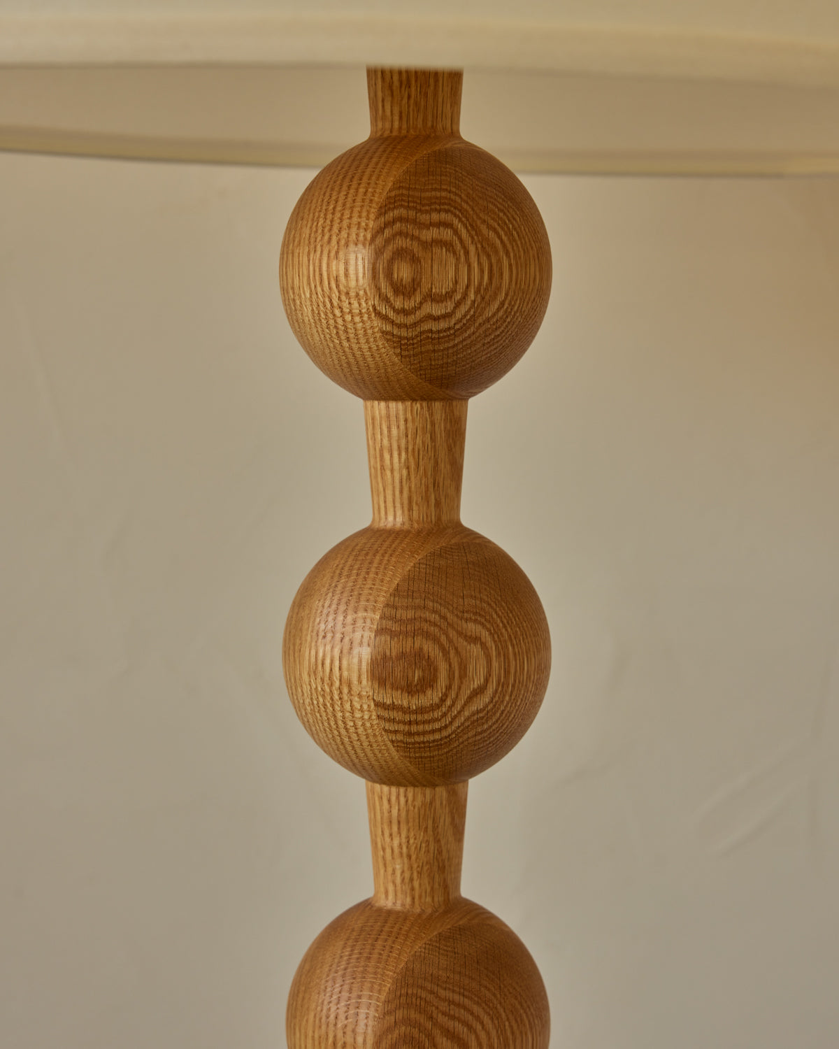 Tall sculptural solid red oak floor lamp with barbell design in natural finish with ivory linen drum shade, best seller, made in the USA 
#color_natural red oak
#shade-color_ivory linen
