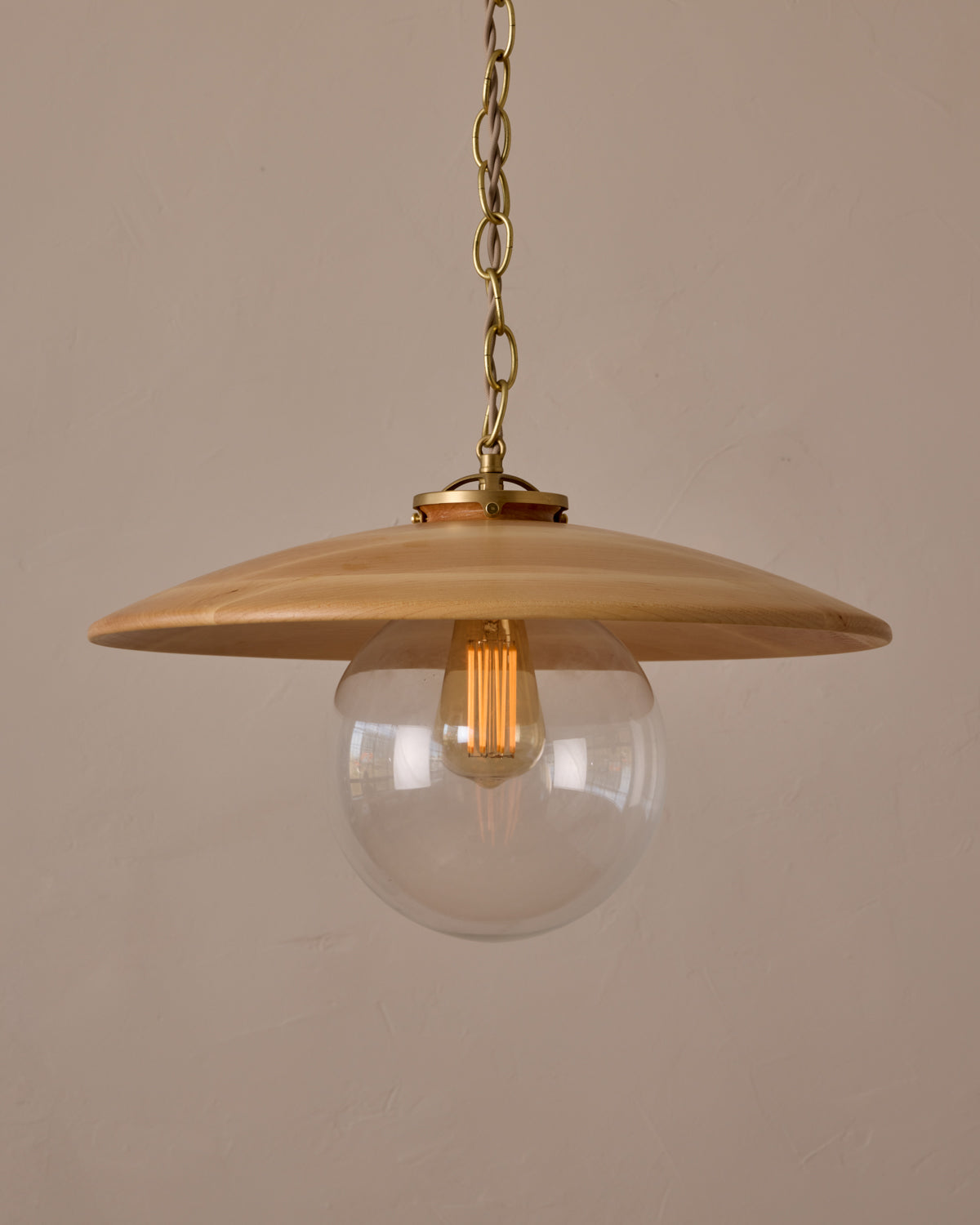 Large pendant light with oversized clear glass globe and decorative wooden clear maple shade with brass chain  #shade-finish_natural maple #globe_clear glass #cord-color_beige
