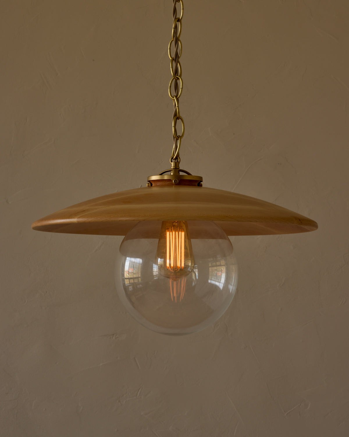 Large pendant light with oversized clear glass globe and decorative wooden clear maple shade with brass chain  #shade-finish_natural maple #globe_clear glass #cord-color_beige