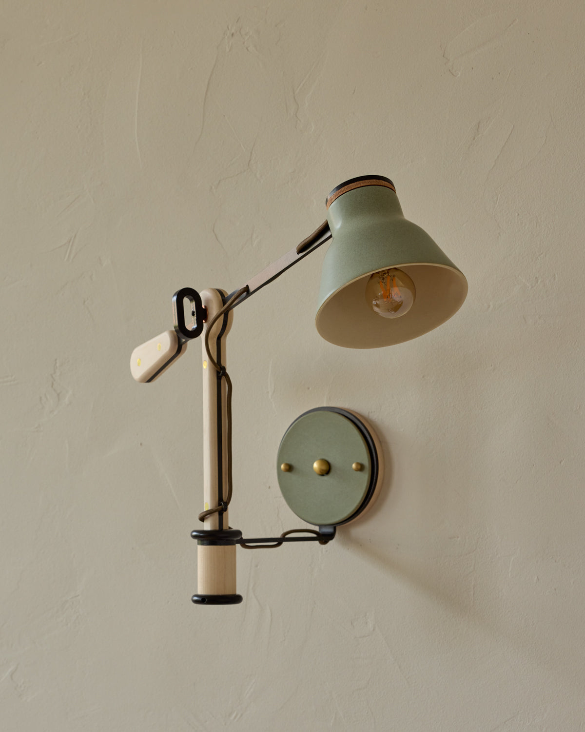 Vintage-style wall lamp with adjustable arm on a beige wall #color_olivine