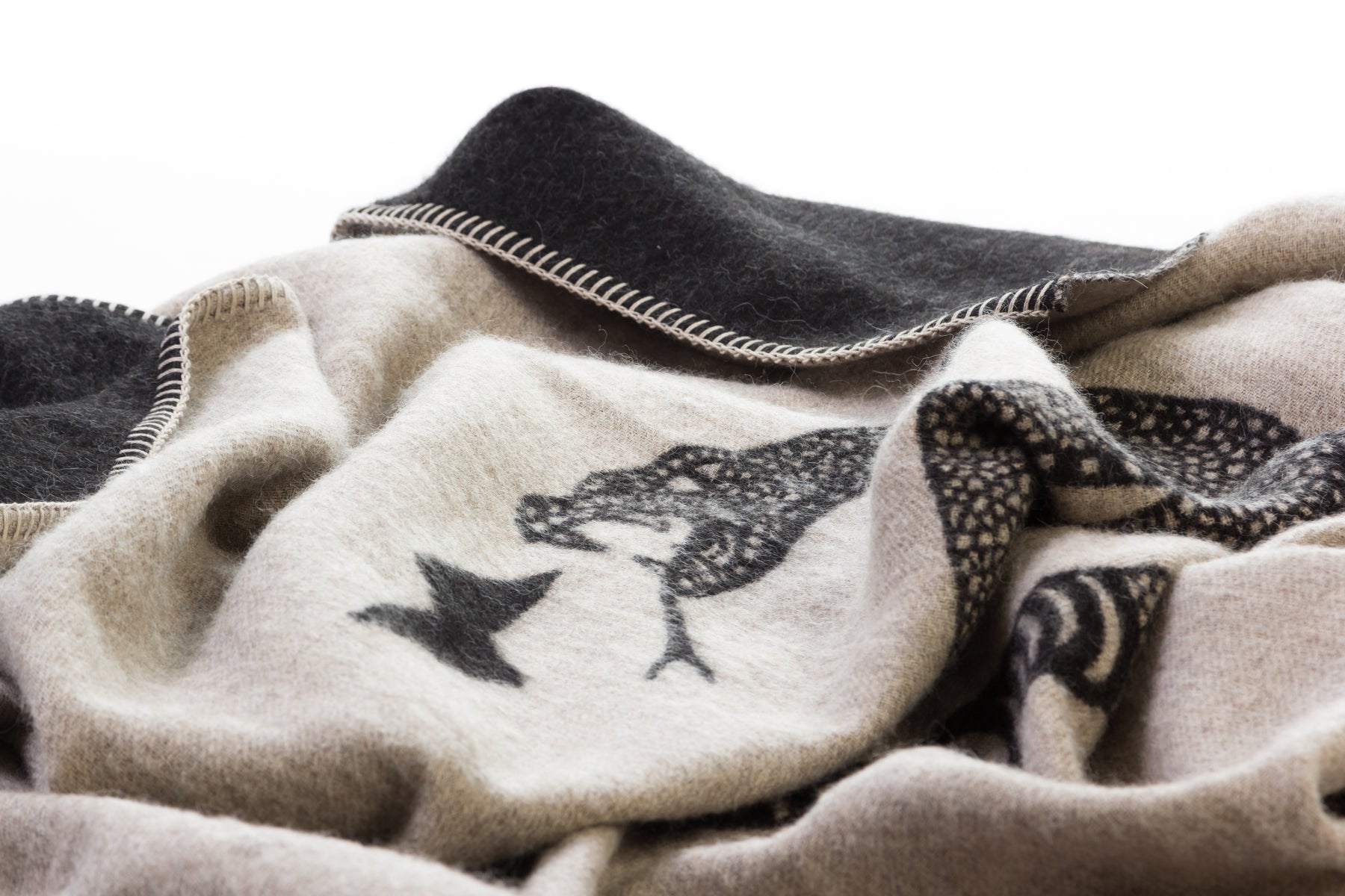 Soft baby alpaca reversible blanket with black and light tan loosely coiled rattlesnake pattern