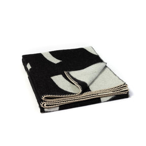 Soft baby alpaca reversible throw with black and white abstract pattern and white stitched edges