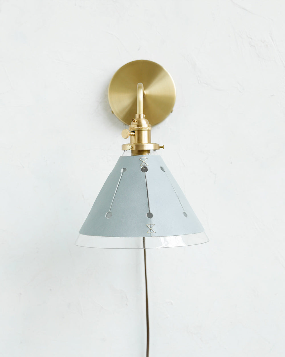 Classic satin brass plug in wall sconce with cone glass diffuser and decorative handstitched leather shade #leather-finish_cloud blue #wiring_plug-in