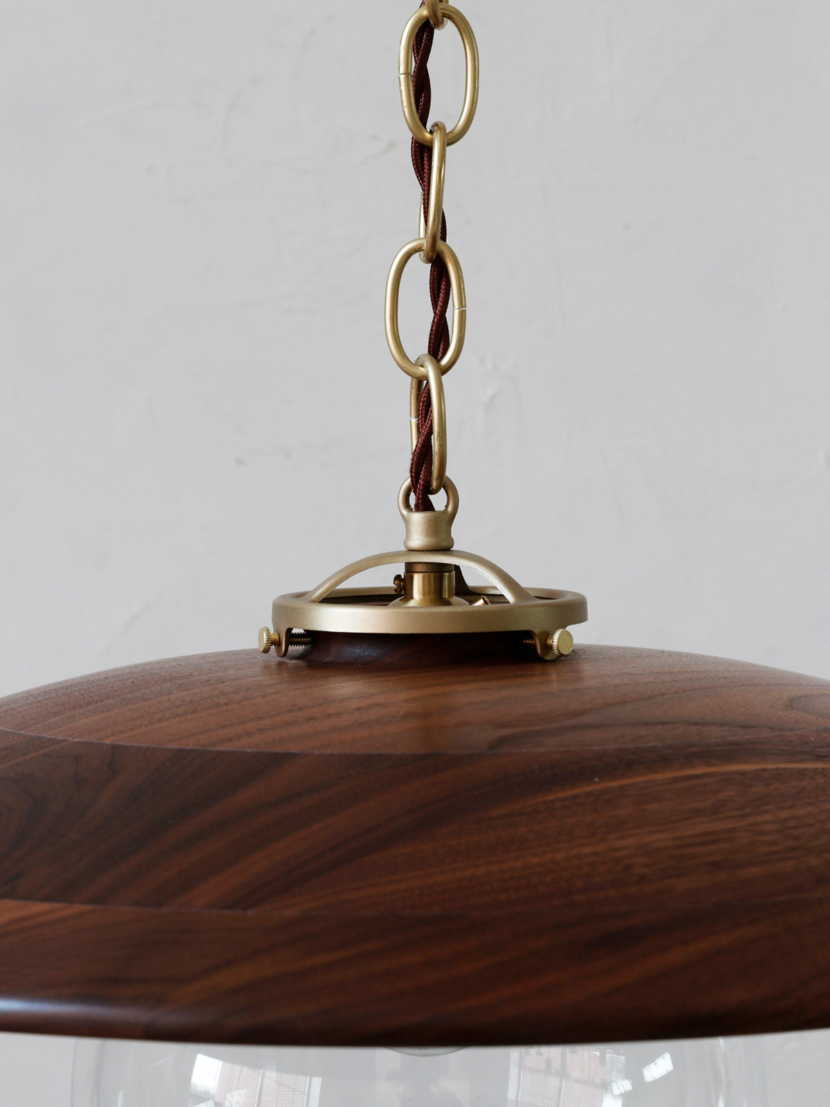 Large pendant light with oversized clear glass globe and decorative wooden black walnut shade with brass chain