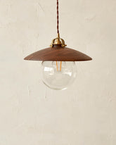 Pendant light with large clear glass globe and decorative wooden black walnut shade. Hardwired or plug light fixture. Made by Lostine in Philadelphia. Simple interior design, made in the USA. Warm American Modern Design