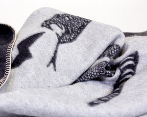 Soft baby alpaca reversible blanket with black and ivory loosely coiled rattlesnake pattern with stitched edges