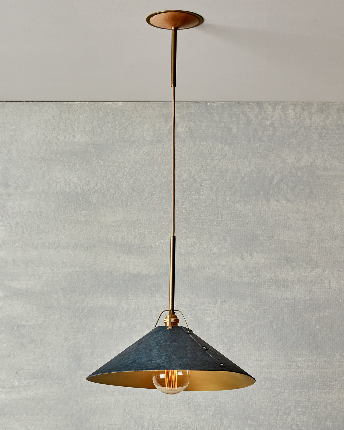 Navy blue leather and brass ceiling pendant light. Made by RTO Lighting in Philadelphia. Hardwired light fixture. Simple interior design, made in the USA.