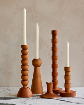 Collection of chery wood candle holders with stark white taper candles