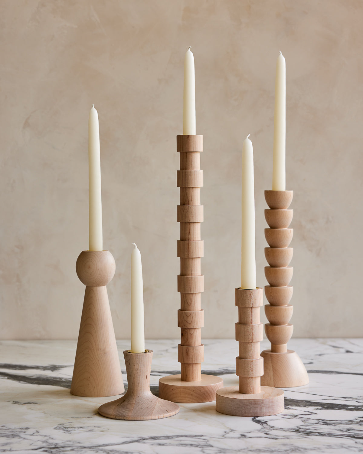 Collection of maple wood candle holders with shell white taper candles