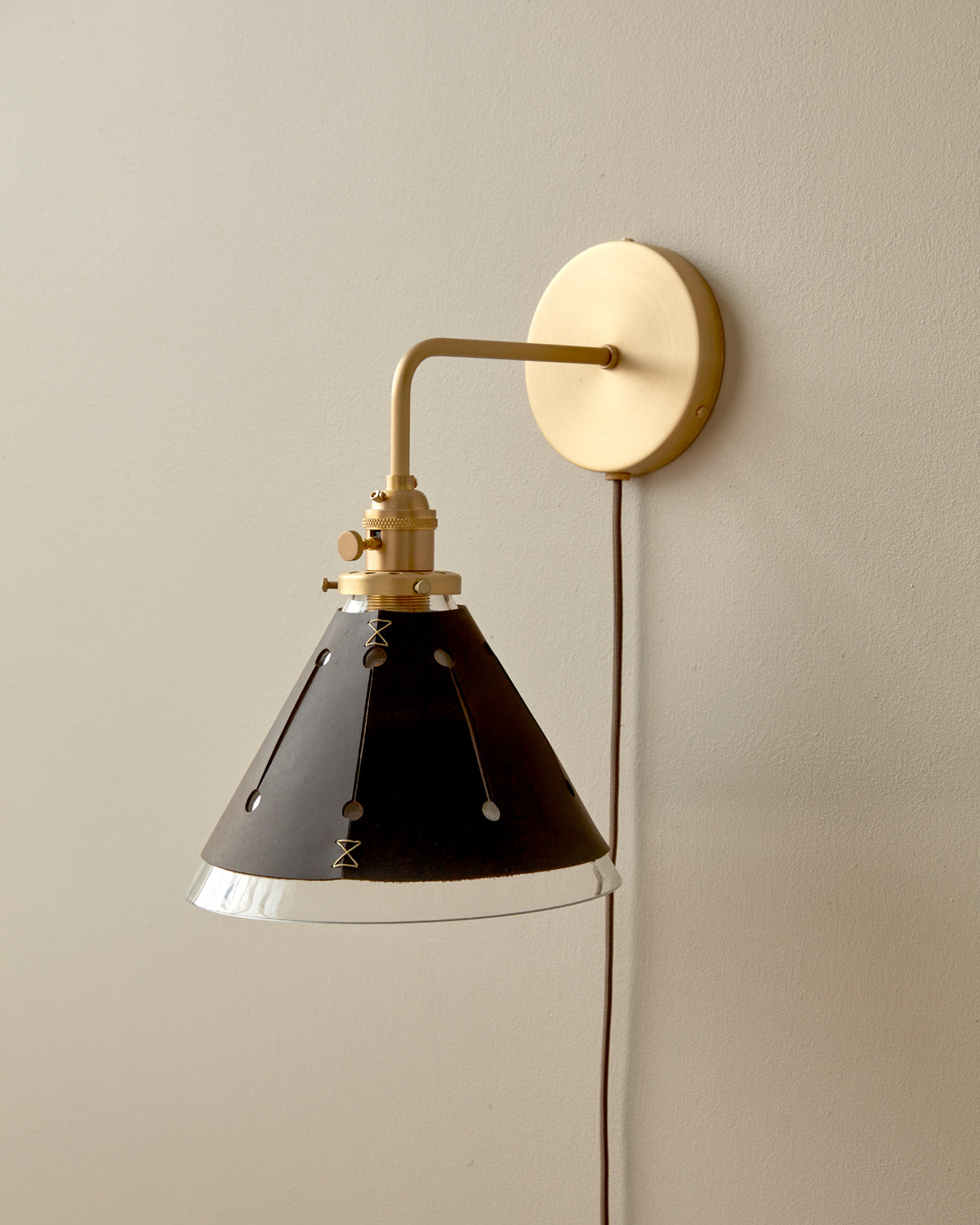 Classic satin brass plug in wall sconce with cone glass diffuser and decorative handstitched leather shade #leather-finish_espresso #wiring_plug-in