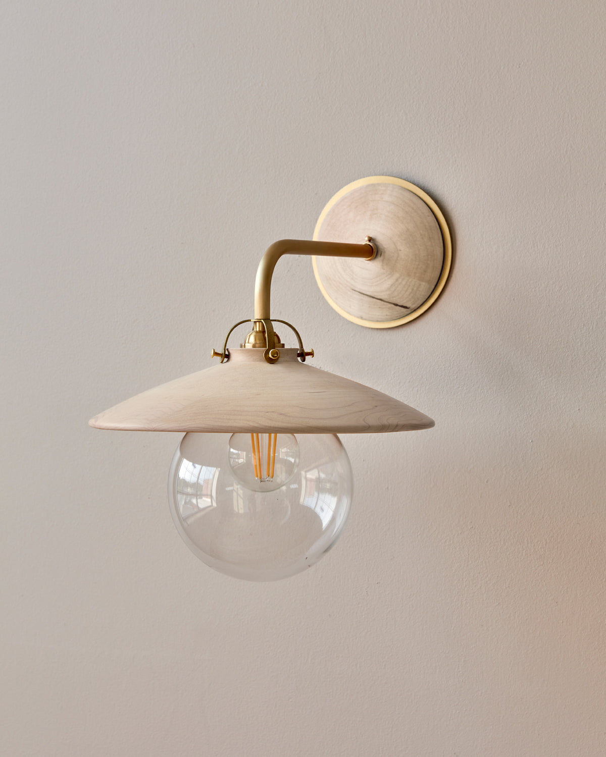 Hardwired satin brass wall sconce with decorative wooden clear maple shade and glass globe