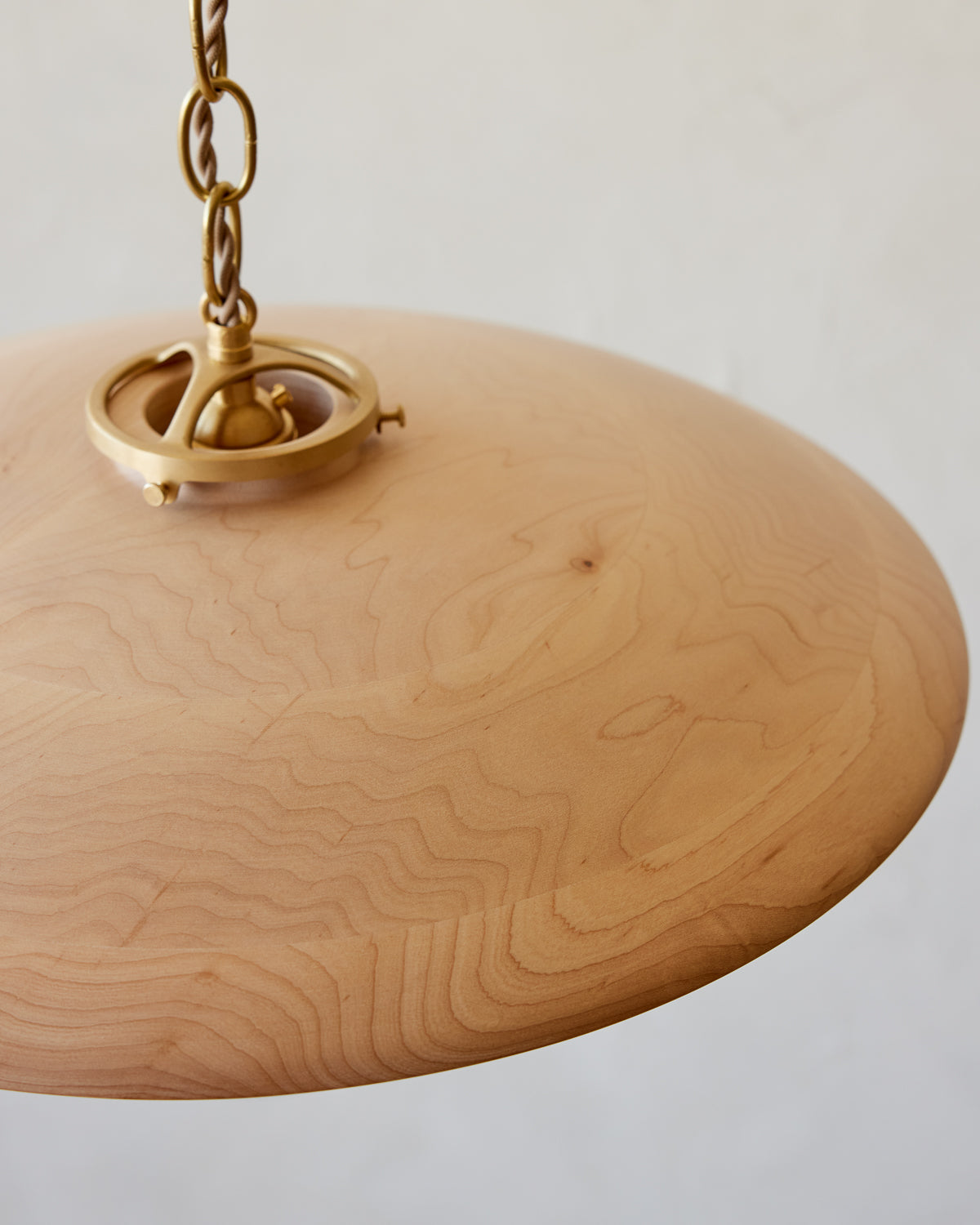 Large pendant light with oversized clear glass globe and decorative wooden clear maple shade with brass chain