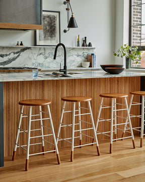 LOSTINE GORDON STOOL - WHITE BASE at modern kitchen counter with marble countertops - Classic ladder metal base stool with wooden seat and feet, workshop stool. Counter and bar height. Made by Lostine in Philadelphia. Simple interior design, made in the USA. Warm American Modern Design