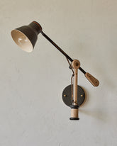 Maple, steel and ceramic wall sconce with articulating arm with matte black stoneware shade