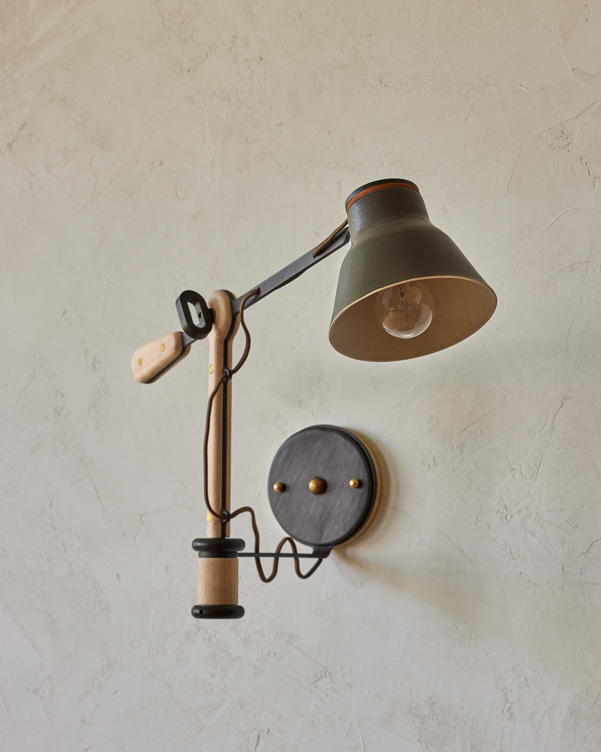 Maple, steel and ceramic wall sconce with articulating arm with matte black stoneware shade