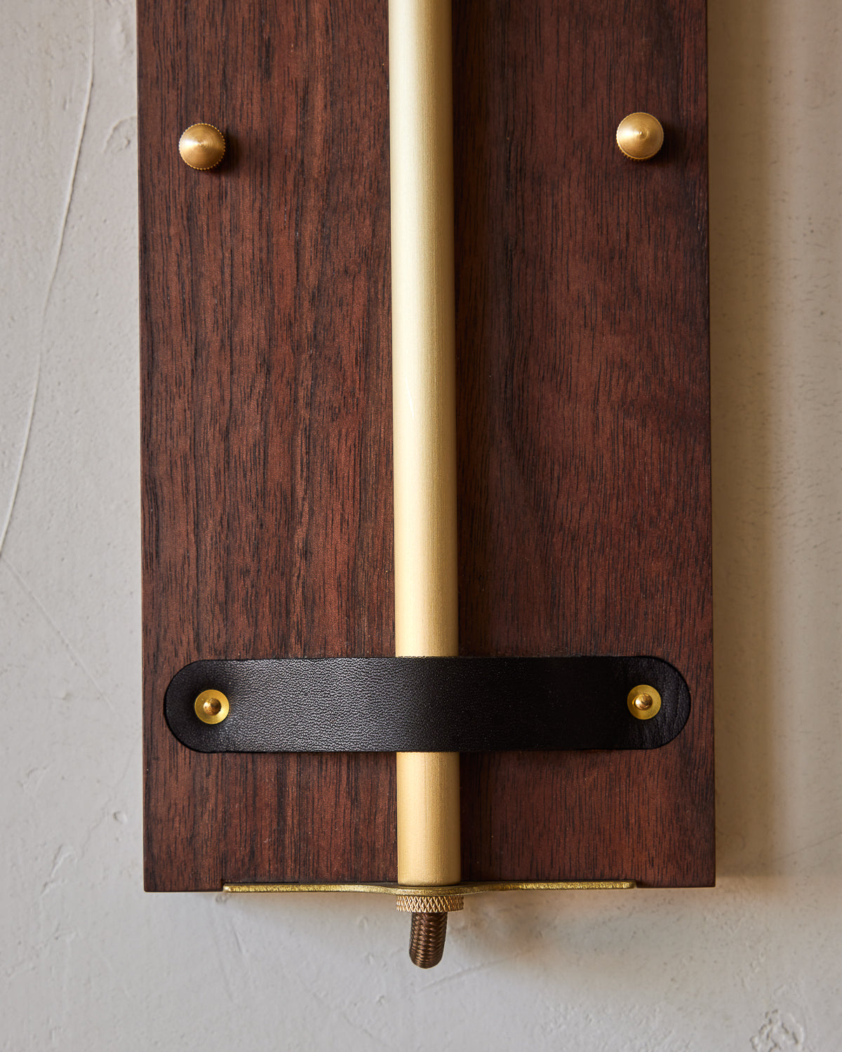 Black walnut wooden wall sconce with articulating brass arm and black leather