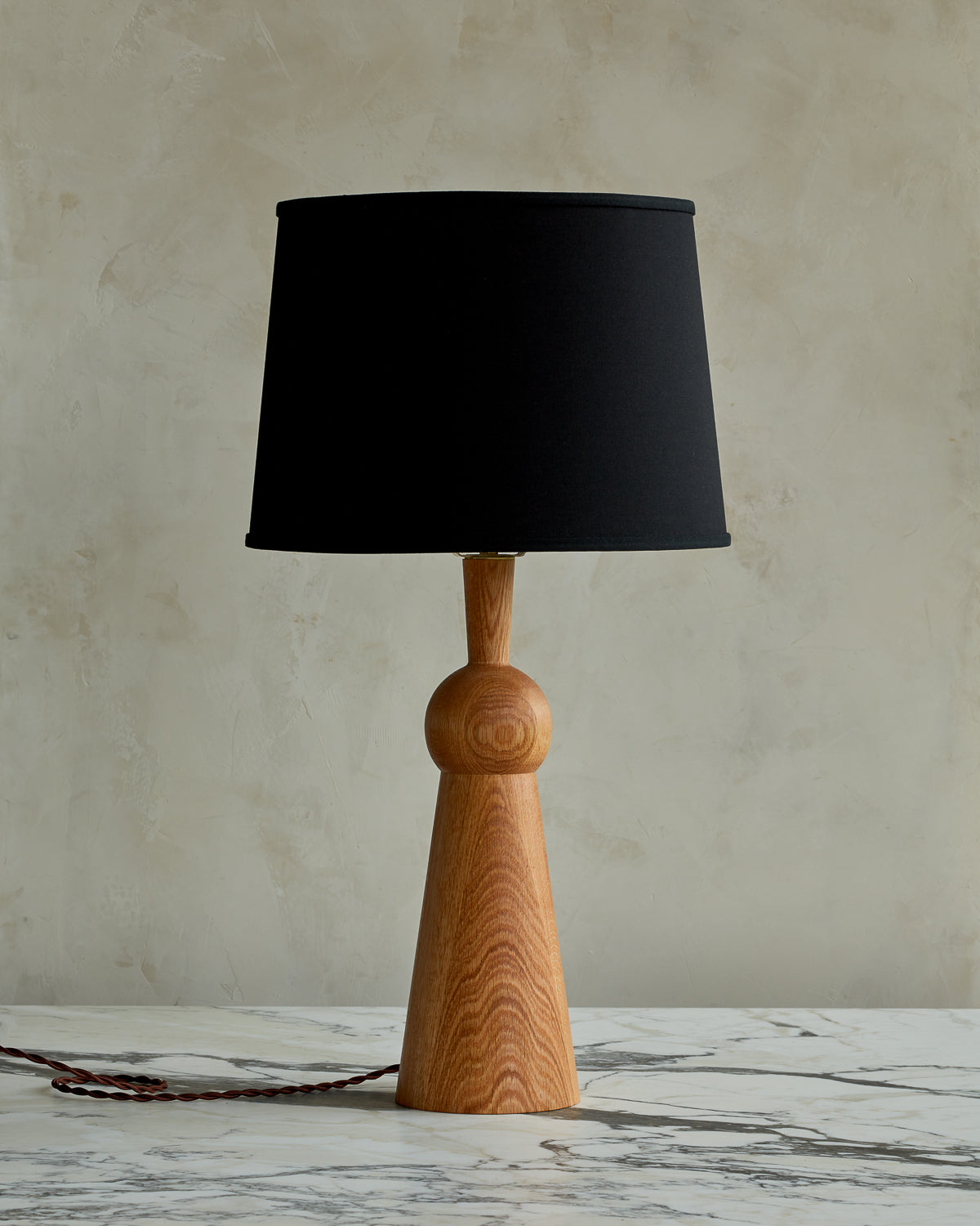 Natural red oak solid wood table lamp with gently tapered body and black linen shade