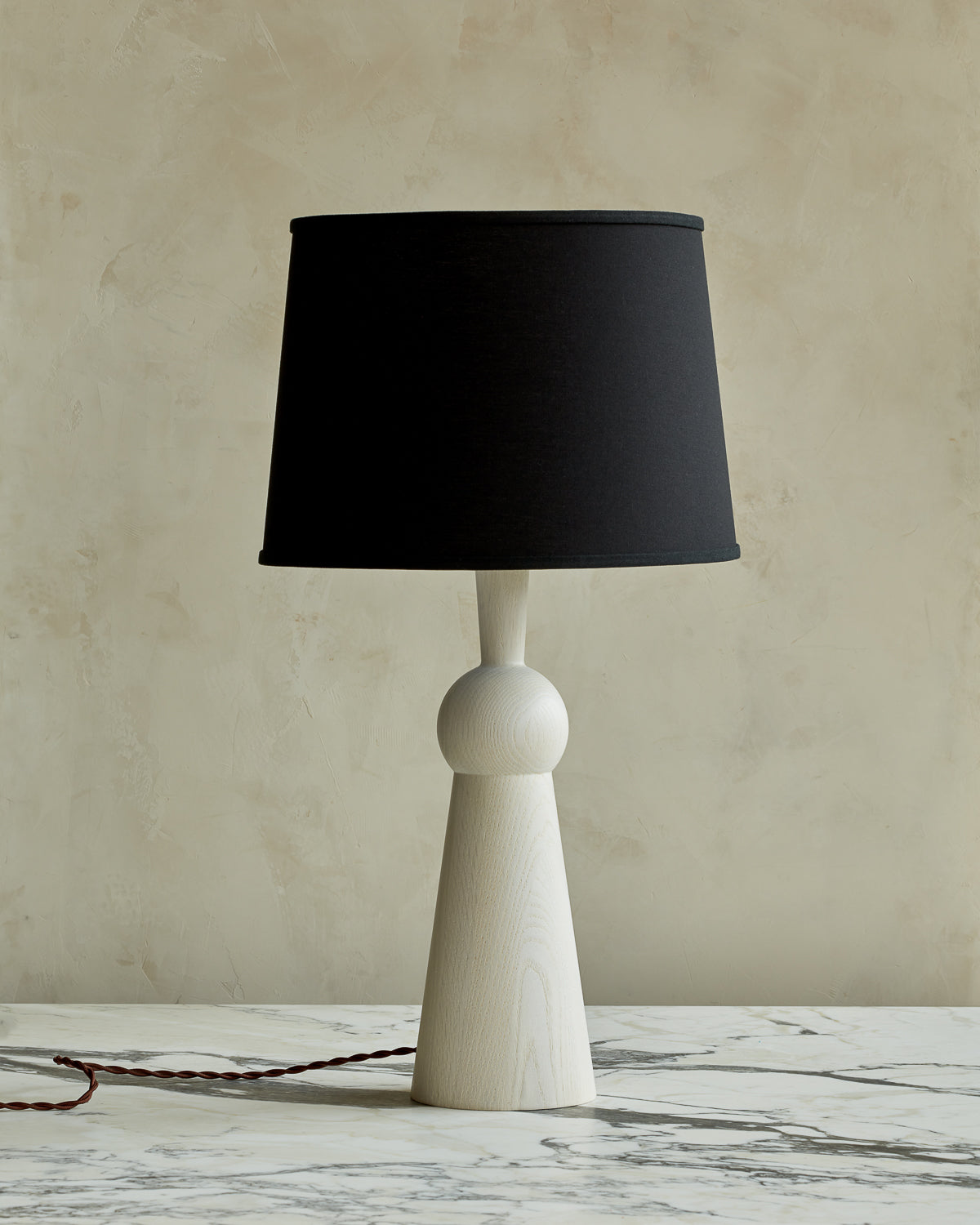 White wash solid wood table lamp with gently tapered body and black linen shade