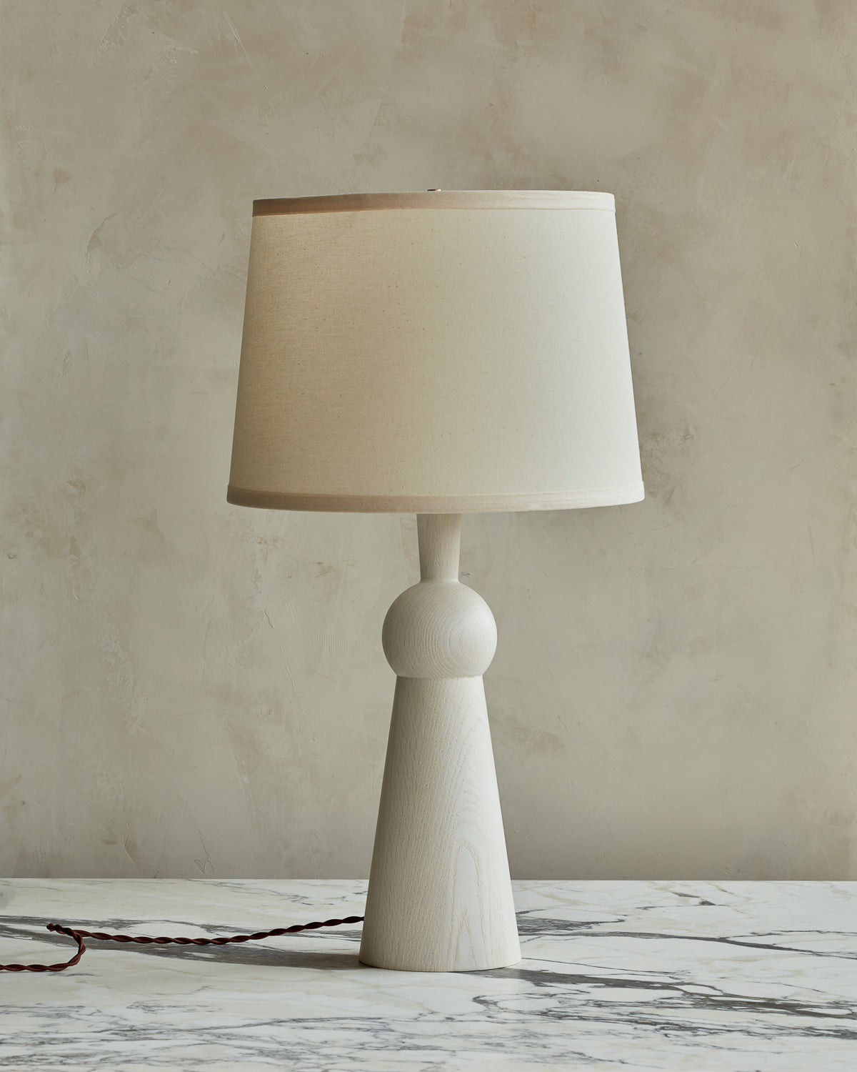 White wash solid wood table lamp with gently tapered body and ivory linen shade
