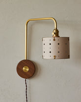 Articulating satin brass plug-in wall sconce with white handstitched shade and walnut backplate