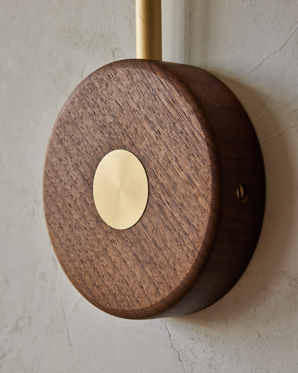 Articulating satin brass wall sconce with white handstitched shade and walnut backplate