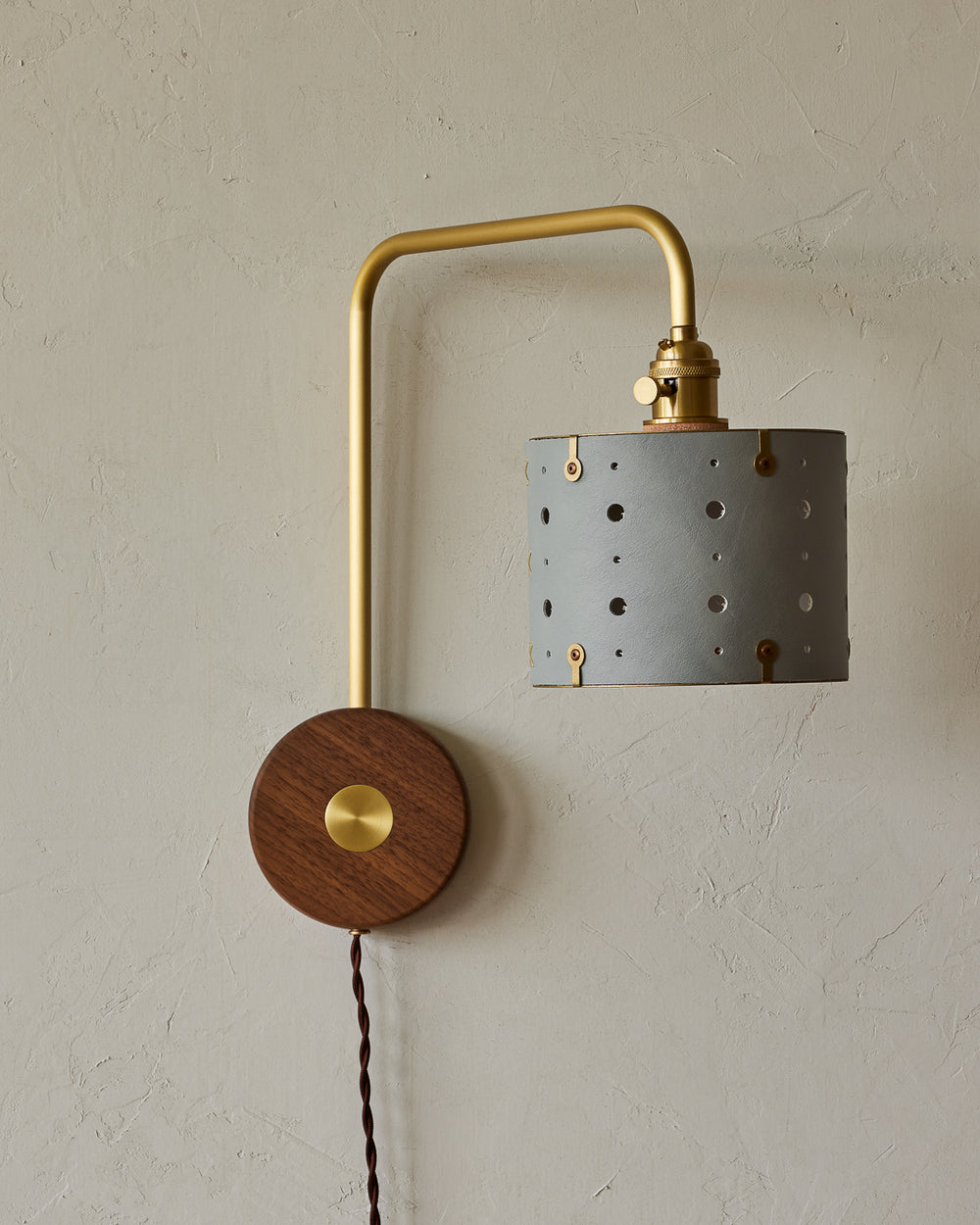 Articulating satin brass plug-in sconce with blue handstitched shade and walnut backplate #leather-finish_cloud blue #wiring_plug-in