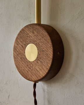 Articulating satin brass sconce with blue handstitched shade and walnut backplate
