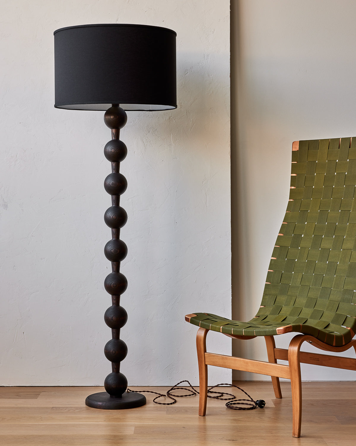 Tall sculptural solid wood floor lamp with barbell design in dark wash finish with black linen drum shade