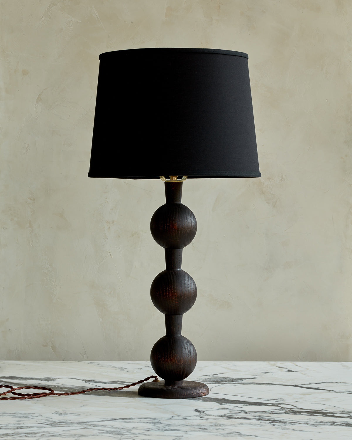 Sculptural solid wood table lamp with barbell design in dark wash finish with black linen shade