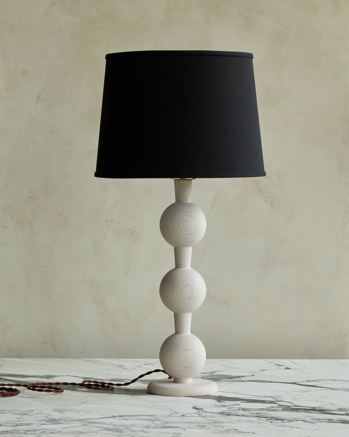 Sculptural solid wood table lamp with barbell design in white wash finish with black linen shade