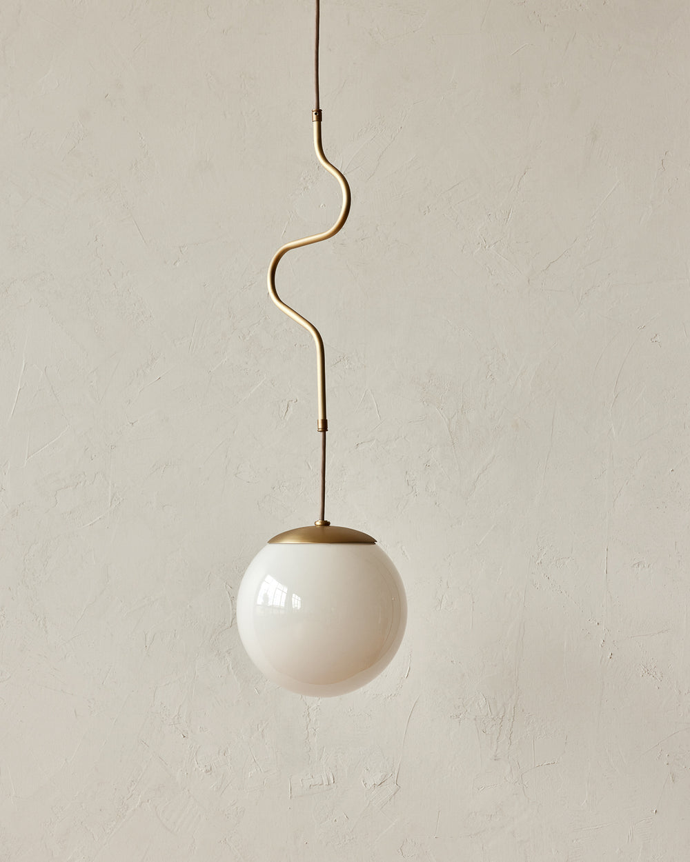 Modern brass globe pendant light with warm satin brass curved body and white milk glass globe #metal-finish_satin brass #size_small