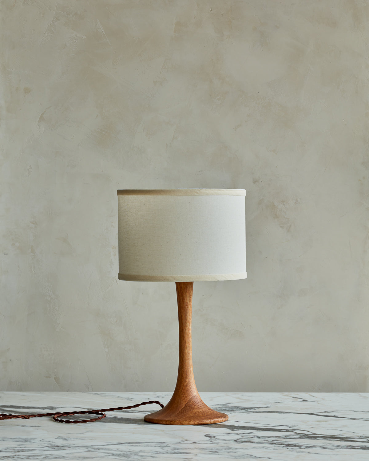 Small Trumpet table lamp with natural finish and ivory drum shade