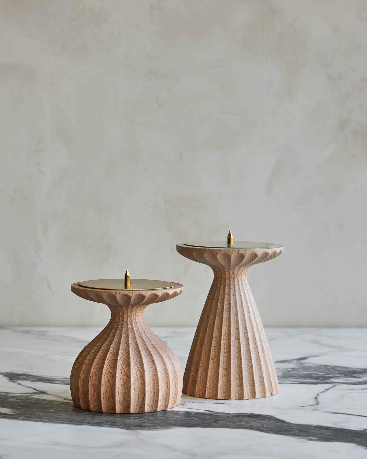 Pair of delicately grooved pillar candle holders in natural maple wood with brass tops