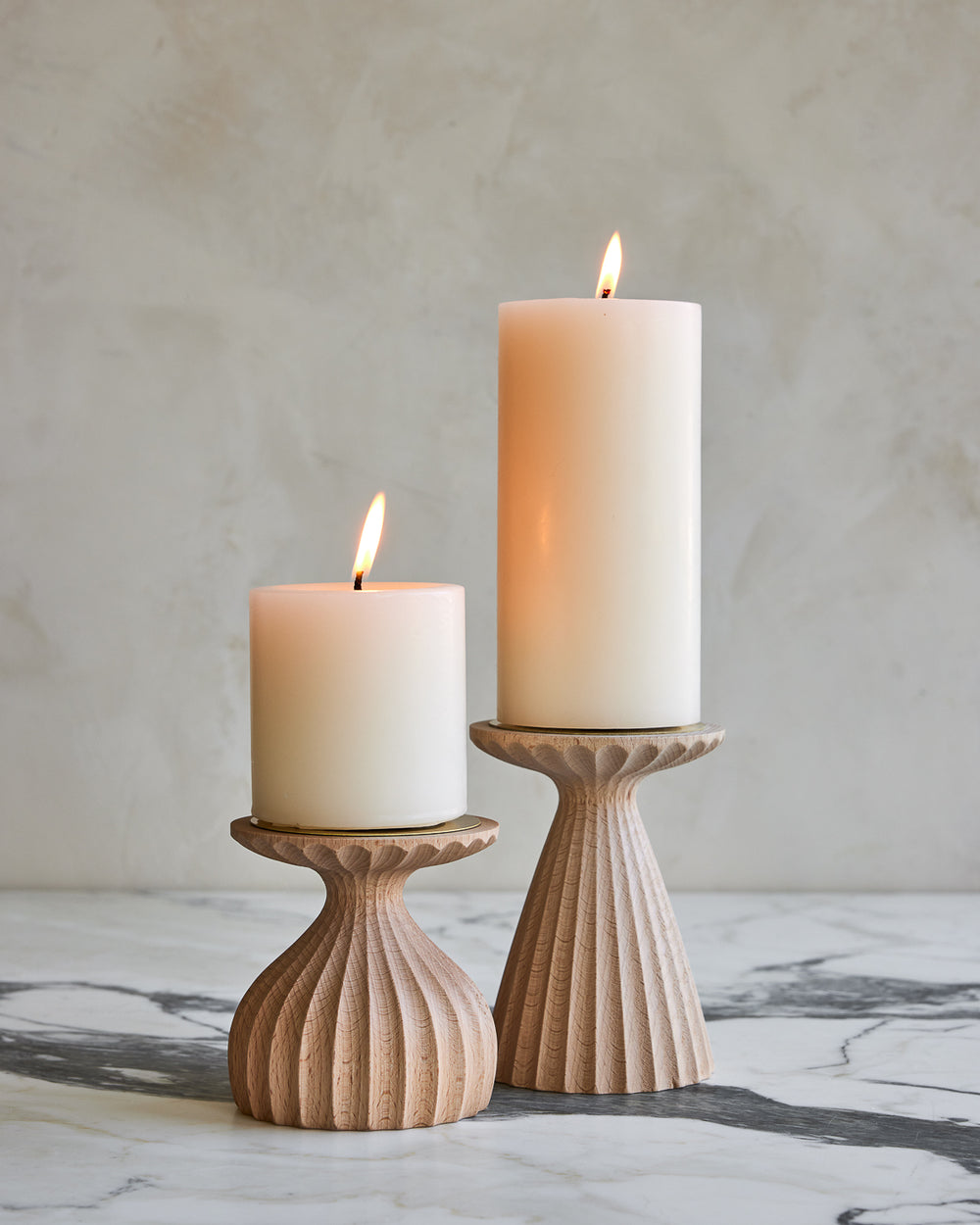 Pair of delicately grooved pillar candle holders in natural maple wood with shell white pillar candles #wood-finish_natural maple