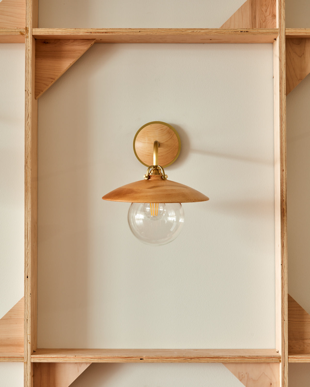 Hardwired satin brass wall sconce with decorative wooden natural maple shade and glass globe
