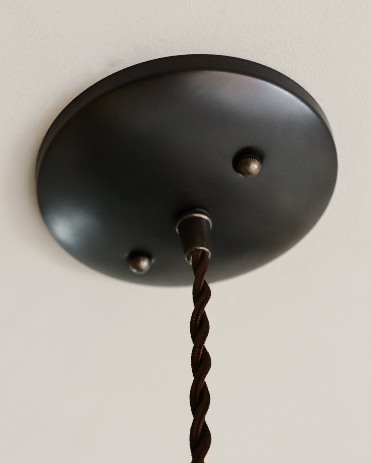 Black leather cylinder pendant with handstitched, perforated leather shade. Made by Lostine in Philadelphia. Hardwired or plug light fixture. Simple interior design, made in the USA.
